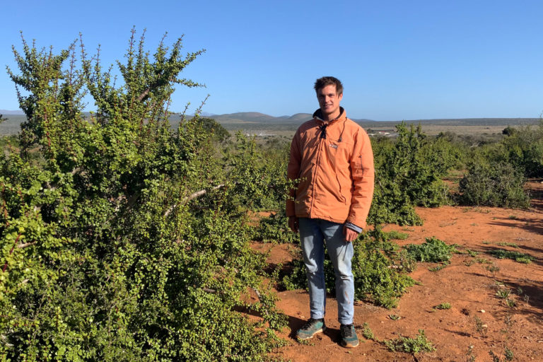 Botanist Keith Steunenberg stands next to a thicket.