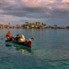 Bajo women canoeing from the village to a tourist beach.