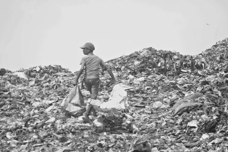 A boy sorts through the waste in a landfill