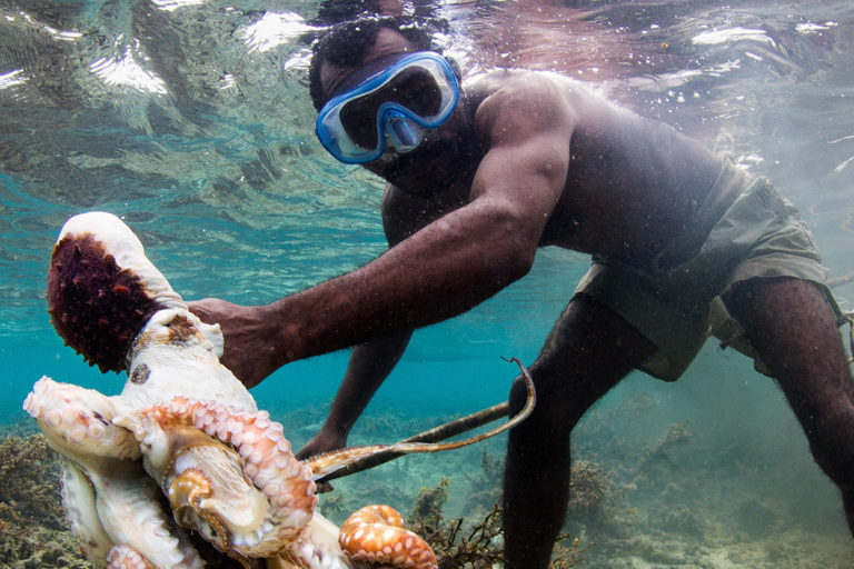 This Vezo fisherman had just speared an octopus. Behind him, the water is discolored by the the ink the octopus had released to try to protect itself. Photo © Garth Cripps / Blue Ventures.