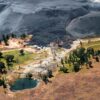 Aerial view of a massive pile of black coal looming over a small pool and scattered trees near Carolina, Mpumalanga, South Africa. Image courtesy Mpumalanga Tourism and Parks Authority.