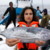 Farah Obaidullah holds a fish on a fishing boat.