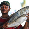A fisherman shows off his catch at a market in Indonesia.