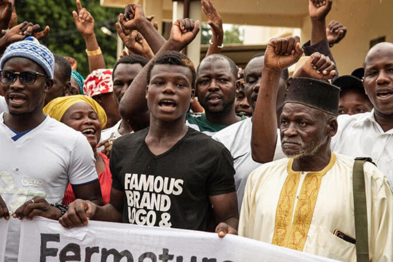 Close up of men chanting at a protest in Cayar, Senegal. Image © Greenpeace / Annika Hammerschlag.
