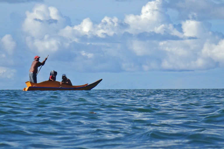 Fishermen in a small boat at sea in Koror, Palau.