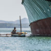 An artisanal fisherman next to a ship in Madagascar.