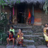 Women from a village in Bali in front of a house that preserves the traditional architecture with earthen wall on the front.