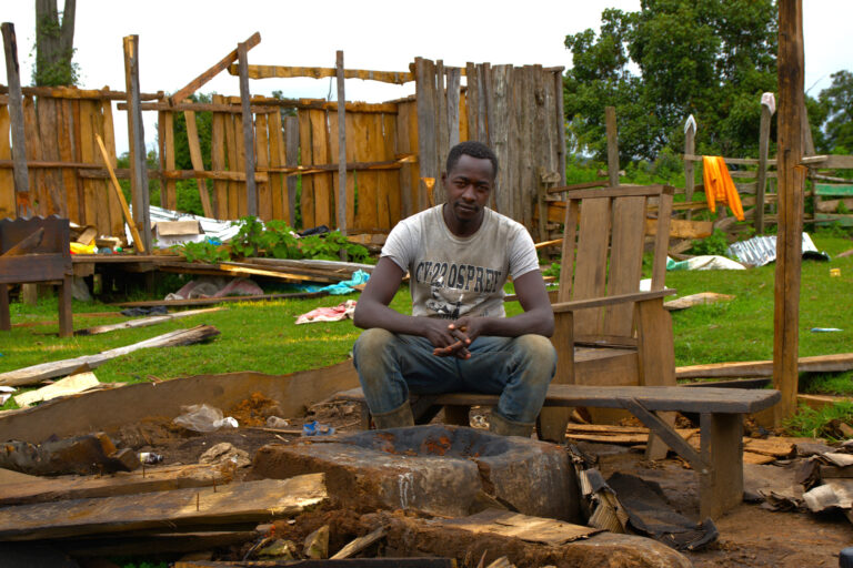 Peter Nagul sit on the rubble that used to be his house.