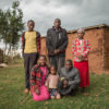 Caroline Chepkoeh poses for a photo with her husband and extended family outside of her home near the Mau Forest Complex in western Kenya. Image by Nathan Siegel for Mongabay.
