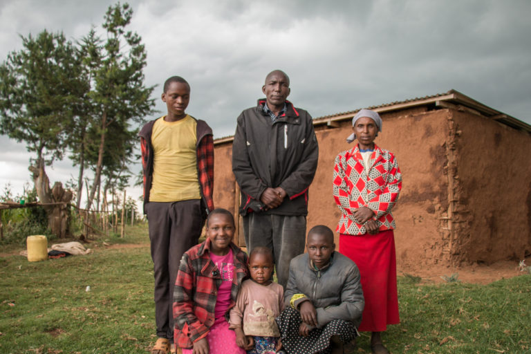 Caroline Chepkoeh poses for a photo with her husband and extended family outside of her home near the Mau Forest Complex in western Kenya. Image by Nathan Siegel for Mongabay.