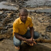 A youth leader demonstrates the impact of oil production on the local community.