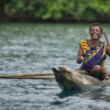 An Indigenous person in a boat.