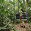 Woman carrying a solar pannel near Yangambi, DRC.