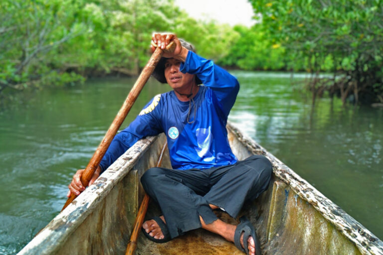 Victor Emata, a SEAMANCOR-trained tour guide, rowing a boat.