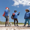 Members of Las Chelemeras consult with Keila Vazquez (in hat) before continuing their work.